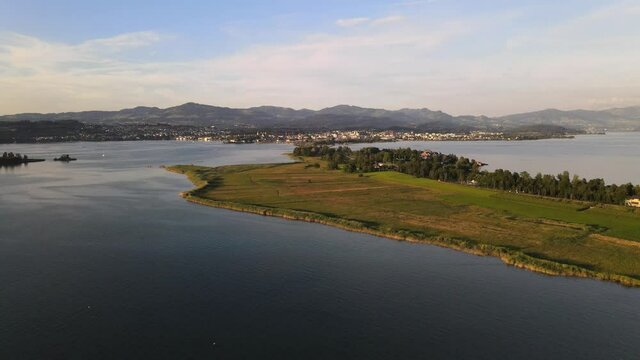 Aerial sideways drone shot flying past Rapperswil and Hurden during a summer sunset