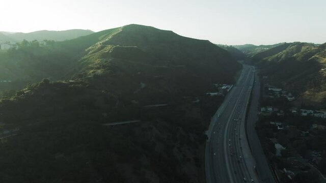 Aerial Panning Shot Of Traffic On Highway By Near Famous Getty Center, Drone Flying Forward Over Vehicles Against Sky At Sunset - Los Angeles, California