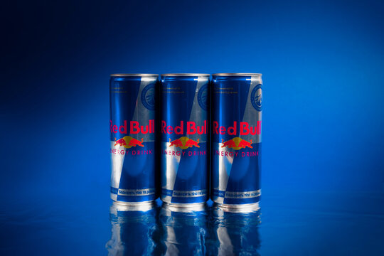 Kiev, Ukraine - july 11, 2021: Three cans of Red Bull energy drink on a blue background