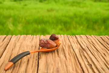 Dried dates with and wooden spoon on oldwooden table