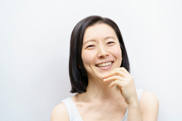 顔を触る日本人女性（40-50代のイメージ）