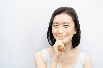 顔を触る日本人女性（40-50代のイメージ）