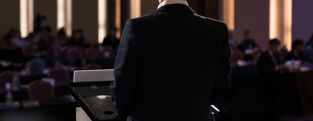 Business People Meeting and Working while Business Executive Lead Presenter Speaks to Group of Successful Technology Entrepreneurs. Consultant Advisor. Growth Training Lecture. Defocused Blurred
