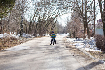 Fototapeta na wymiar A little Caucasian boy 2 years old learns to ride a balance bike