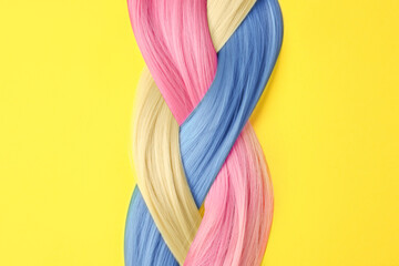 Samples of hair dyed in different colors on yellow background
