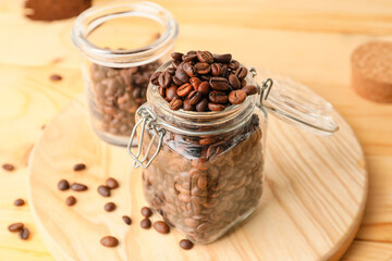 Jar with coffee beans on wooden background