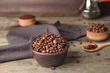 Bowl with coffee beans on wooden background