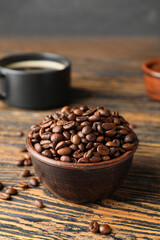 Bowl with coffee beans on wooden background