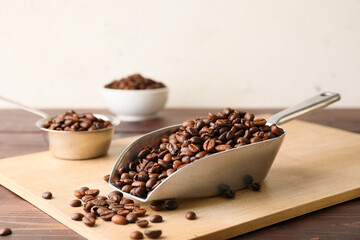 Scoop and pot with coffee beans on wooden background