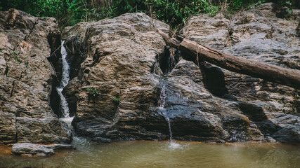 Waterfall in the forest in the middle of the valley.