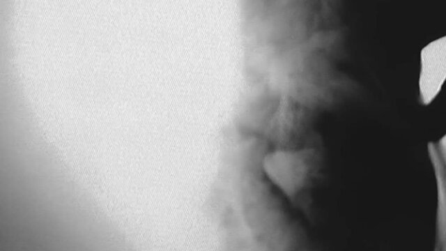 Occult ritual. Real VHS video glitch. Esoteric practice. Analog noise. Psychic woman in black performing spiritual dance in white mist cloud with grain flicker distortion.