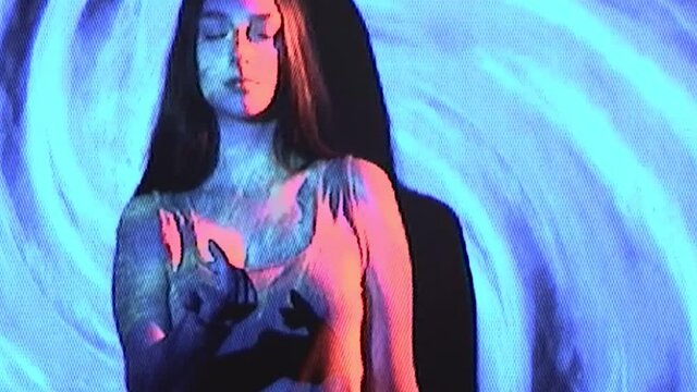 Analog VHS video. Hypnosis therapy. Real glitch noise. Telepathy mind control. Woman beckoning inviting to follow with finger gesture in pink neon light on blue spiral background.