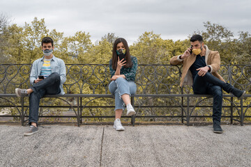 Millennial generation young people using smartphone wearing face mask