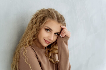 the face of a beautiful Caucasian girl in close-up against a gray wall copy space.attractive modest...