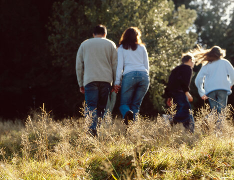 Family walking up grassy hill in natural setting