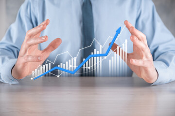 Businessman man holding a graph with positive profits growth. plan graph growth and increase of chart positive indicators in his business.more profitable and growing