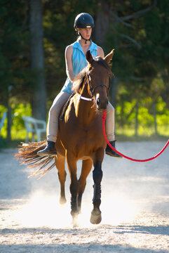 Teenage girl riding horse bareback on lunge rope