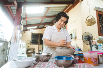 Authentic portrait asian elderly woman cooking local traditional thai style food.
