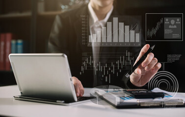 Business women using tablet with laptop and document on desk in office with virtual interface graphic icons network diagram.