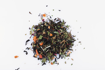 a handful of dry tea from leaves, fruits and flowers on a white background close-up