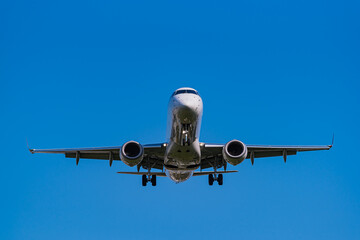 青空背景に着陸態勢に入るジェット機