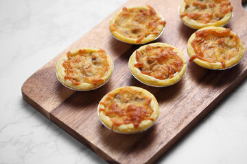 Mini pie from meat and mushrooms in wooden tray