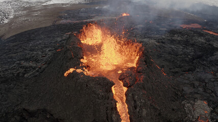 lava eruption volcano with snowy mountains, Aerial view
Hot lava and magma coming out of the crater, April 2021 
