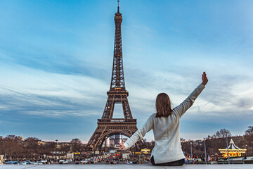 Fototapeta na wymiar Young girl on vacation in paris with the Eiffel tower in the background