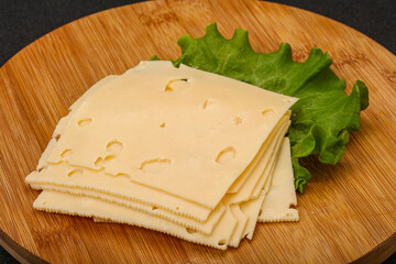 Sliced yellow cheese over board