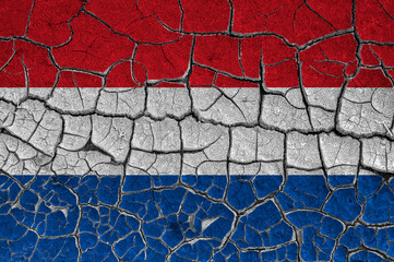 Flag of Netherlands on a cracked wall, dry ground