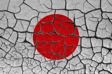 Flag of Japan on a cracked wall, dry ground