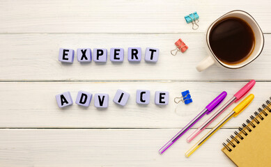 Cubes with the abbreviation EXPERT ADVICE, coffee and office supplies