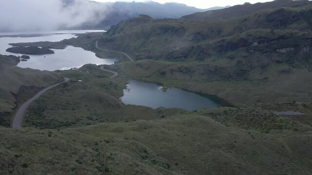 Aerial forward flight showing natural Atillo Lake during foggy day in wilderness of Ecuador.