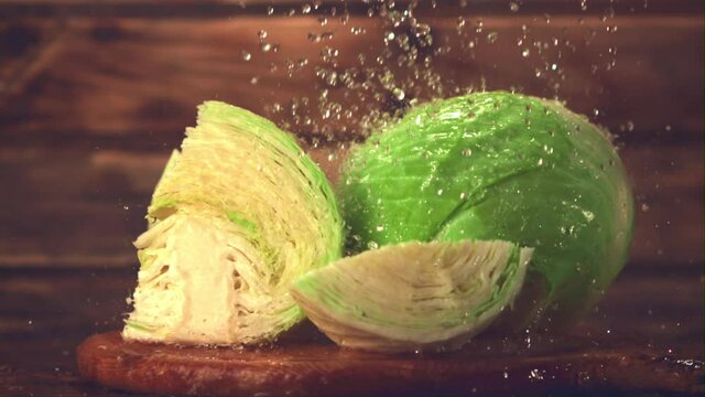 Super slow motion on the pieces of cabbage drop drops of water. Filmed on a high-speed camera at 1000 fps.On a wooden background. 