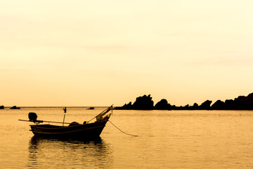  Summer day. Sunset streams through the clouds with fishing boat waves blow to the beach.