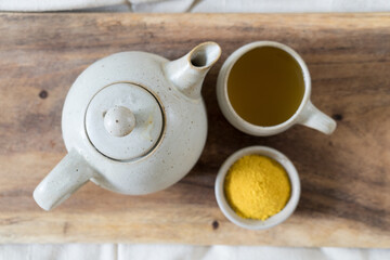 Top view of ceramic tea pot and turmeric ginger tea 