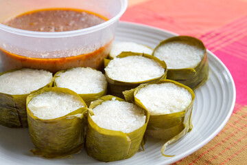Lemang on a plate with curry sauce.