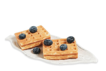 Waffles and blueberries on plate on white background, isolate.