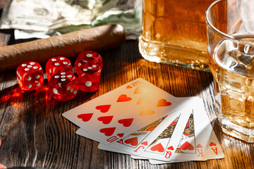 Playing poker with whiskey and cigars on table