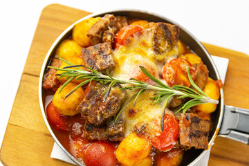 Meat with potatoes and vegetables in a frying pan