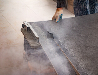 male hands of  construction worker sawing and cutting parts of  electric miter saw from  wooden...
