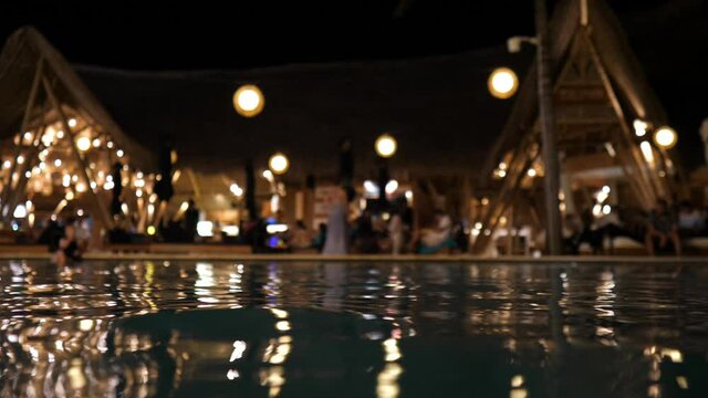  View from the water of the hotel party by the pool at the night