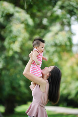 Fototapeta premium Mother and cute baby having fun in nature park 