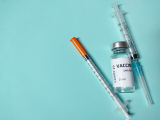Covid-19 vaccine with insulin syringes on blue background 2019-ncov medicine bottle and injection...
