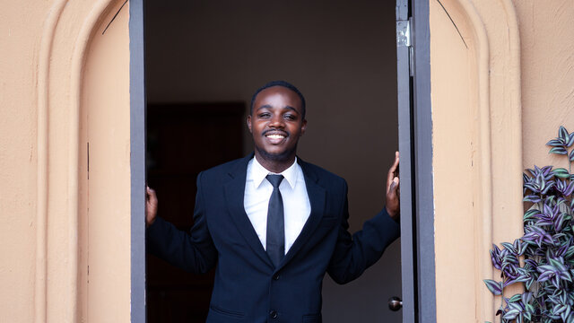 Friendly african businessman standing with open the doors