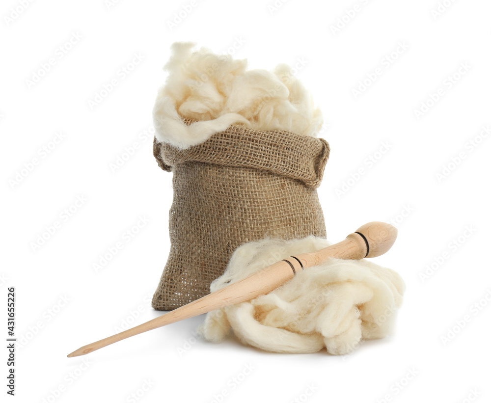 Wall mural Soft wool in sack and spindle on white background