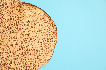 Tasty matzo on light blue background, top view with space for text. Passover (Pesach) celebration