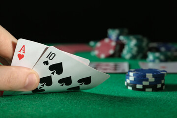 Man playing poker at table with casino chips, closeup. Space for text