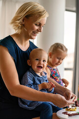 Family activities in the kids room. Woman and children playing together.