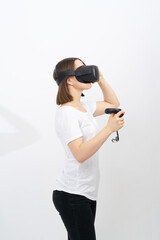 Woman in white holds black VR controllers. First in virtual reality wireless headset and system created. Girl on white background